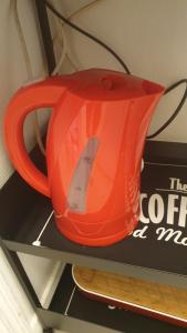 an orange tea kettle sitting on top of a shelf at Le Galope, Appartement centre Compiègne in Compiègne