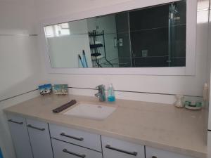 een badkamer met een wastafel en een grote spiegel bij mi casa es su casa in Ashkelon