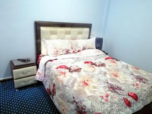 1 Schlafzimmer mit einem Bett mit Blumenbettdecke in der Unterkunft Best Room in Fès