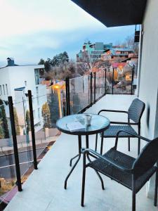 uma varanda com 2 cadeiras e uma mesa na varanda em 5 Star Residence em Brasov