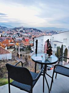 a table and chairs on a balcony with a view of a city at 5 Star Residence in Braşov