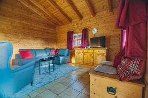 uma sala de estar com um sofá e uma televisão numa cabina em Ruhige Chalets mit Seeblick in zentraler Lage em Schliersee