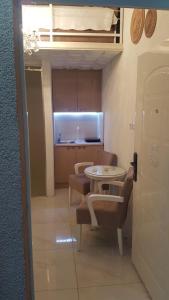 um quarto com uma mesa e cadeiras e uma cozinha em Nusha Apartments em Belgrado