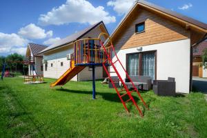 a playground with a slide in front of a house at Domki Apartamentowe Kierunek Rozewie in Jastrzębia Góra