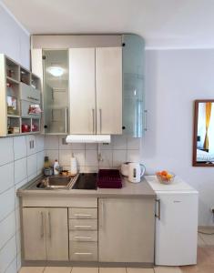 a kitchen with white cabinets and a sink at City Center Lovely Studio Apartment in Belgrade