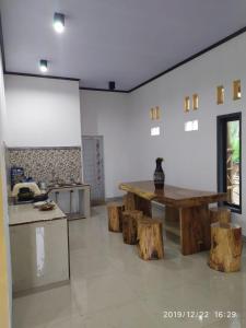 a kitchen with a wooden table and some logs at KOPIKUIN bromo homestay in Probolinggo