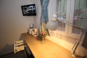 a desk with a lamp and a vase of flowers on it at 92 Residence in Braşov +61 photos