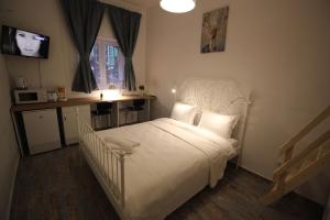 een slaapkamer met een wit bed en een televisie bij 92 Residence in Braşov