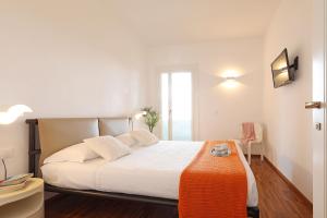 a bedroom with a white bed with an orange blanket at Villa Laura Aegilium in Giglio Porto +31 photos