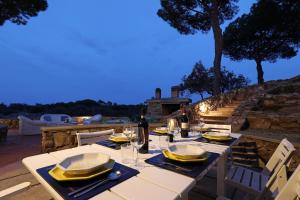 einen Tisch mit Tellern und Weingläsern auf einer Terrasse in der Unterkunft Villa Laura Aegilium in Giglio Porto