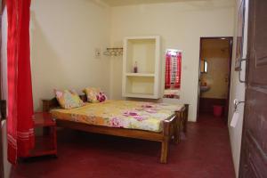 una piccola camera con letto e specchio di Sukriti beach Resort a Varkala