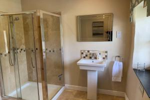 a bathroom with a shower and a sink and a shower at Sygun Cottage - Detached Cottage in the heart of the Snowdonia National Park in Beddgelert +16 photos