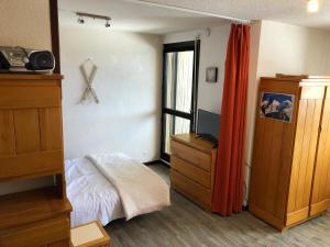 a bedroom with a bed and a dresser and a window at Les Cimes in Samoëns