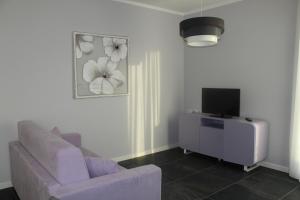 een woonkamer met een bank en een tv bij Abelia 4 in Pietra Ligure