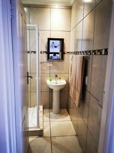 a small bathroom with a sink and a shower at Guest House Mamma Mia in Nelspruit +61 photos
