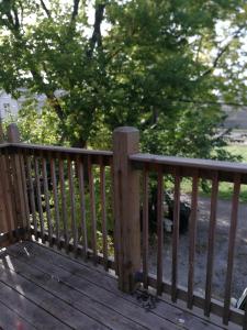 a wooden railing on a deck with trees in the background at 5430 Happy Home in Chicago