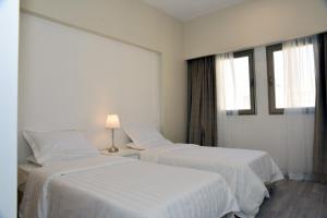 two beds in a white room with a window at salmiya - Amman -Family only in Kuwait