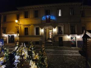 un edificio con árboles de Navidad delante de él por la noche en Dimora del Podestà, en CastellʼArquato