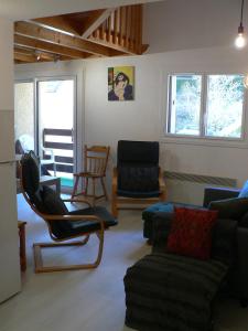 een woonkamer met een bank, stoelen en ramen bij Triplex Idéal Famille in Cauterets
