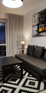 - un salon avec un canapé et une table dans l'établissement Apartament Centrum, à Malbork