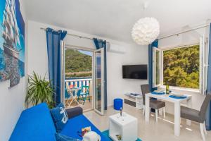 uma sala de estar com um sofá azul e uma mesa em Apartments More em Sobra