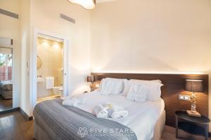 1 dormitorio con 1 cama blanca grande y toallas. en Villa Artemys - Five Stars Holiday House en Saint-Jean-Cap-Ferrat