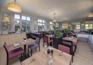 un restaurant avec des tables en bois et des chaises violettes dans l'établissement Hotel Sněžka, à Špindlerův Mlýn