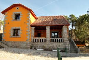 une petite maison orange avec un escalier en face de celle-ci dans l'établissement Casa Rural Mansion Adela con Piscina y Jacuzzi, à Collado Mediano