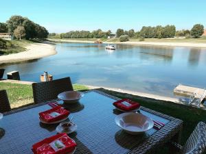 een picknicktafel met uitzicht op een rivier bij Vizafogó Panzió és Étterem in Baja