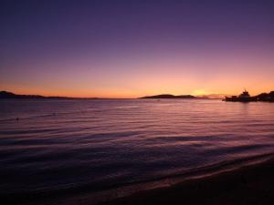 a sunset over a body of water with a boat at Dva lava in Podaca