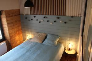 a bedroom with a blue bed and two lamps at Appartement atypique au coeur de Gap in Gap