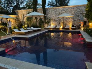 a swimming pool with chairs and umbrellas in a yard at Hotel Morelia Boutique Villa Italia in Morelia