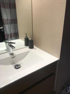 y baño con lavabo blanco y espejo. en Clínica Las Condes, espectacular departamento nuevo 80 m2 en Santiago