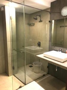 a bathroom with a glass shower and a sink at Calangute Wave in Calangute