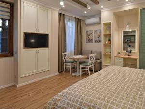 a bedroom with a bed and a table and chairs at Divona Studio 2 in Ruse