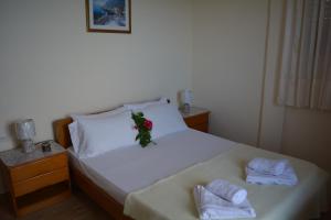 a bed with two towels and a flower on it at FIORE ROOMS in Akrotiri