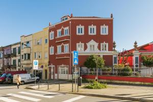 a person crossing a street in front of a building at Solar Studio Campanhã in Porto