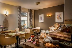 a restaurant with tables and chairs and a fireplace at Aparthotel Ons Epen in Epen