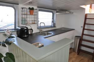 a kitchen with a sink and a counter top at Private Lodge on Houseboat Amsterdam in Amsterdam