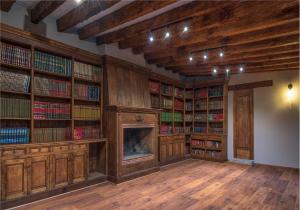 biblioteca con estanterías de madera y chimenea en Hotel Morelia Boutique Villa Italia en Morelia