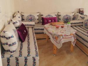 ein Zimmer mit einem Sofa und einem Tisch mit Kissen in der Unterkunft Best Room in Fès
