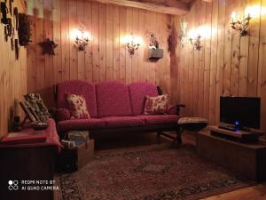 a living room with a red couch and a tv at Appartamento Lo Bou in Valsavarenche