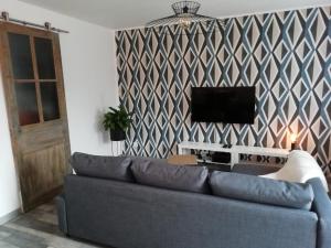 a living room with a couch and a tv at La Petite Pause in Verlinghem