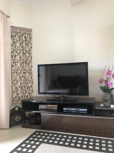 a living room with a flat screen tv on a entertainment center at Aconchego próximo à Cascanéia e Blumenau in Gaspar