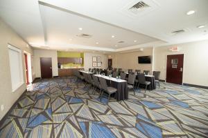a conference room with tables and chairs on a carpet at Holiday Inn Express Hotel & Suites Clinton by IHG in Clinton