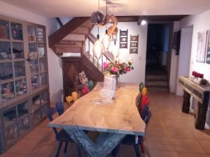 une salle à manger avec une table en bois et des chaises colorées dans l'établissement Maison de gesves, à Gesves