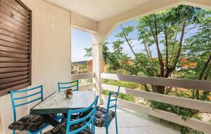 a table and chairs on a porch with a view of trees at Apartmani Jadra in Stara Novalja