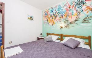 a bedroom with a bed with a painting on the wall at Apartmani Jadra in Stara Novalja