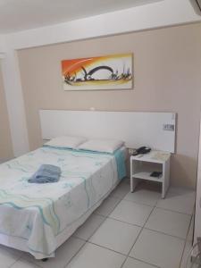 1 dormitorio con 1 cama y una pintura en la pared en Marsallis Elegance Flat, en Natal