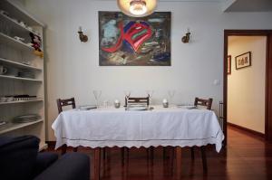 a dining room with a white table with chairs and a painting at NANA in Bilbao in Bilbao